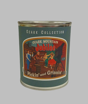 A tin labeled "The Scented Palette Candle Pickin' & Grinnin'" from the prestigious Ozark Collection, featuring an illustration of lively musicians and dancers on stage.