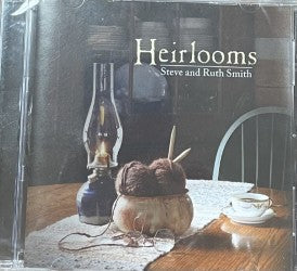 CD cover of the album "Heirlooms" by Steve and Ruth Smith showcases a table adorned with items like a lamp, a yarn ball, knitting needles, and a teacup.