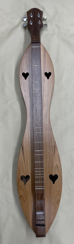 A beautifully crafted 4 String Flathead Hourglass dulcimer, with heart-shaped sound holes and boasting Walnut back and sides along with a Cherry top, rests gracefully on a light background.