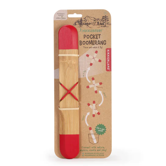 Huckleberry Pocket Boomerang in a cardboard package, featuring a wooden boomerang with red ends and instructions for use in an open outdoor space, including tips on understanding wind direction for better performance.