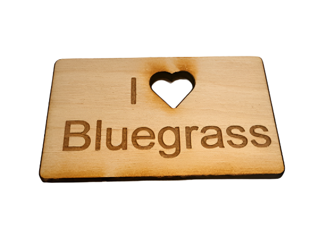 A wooden magnet with "I [heart] Bluegrass" engraved, featuring a heart-shaped cutout.
