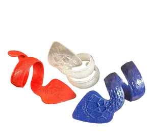 Three SnakePick spiral-shaped plastic wristbands—red, white, and blue—are displayed on a black background. Each features a textured, embossed pattern on its wider end.