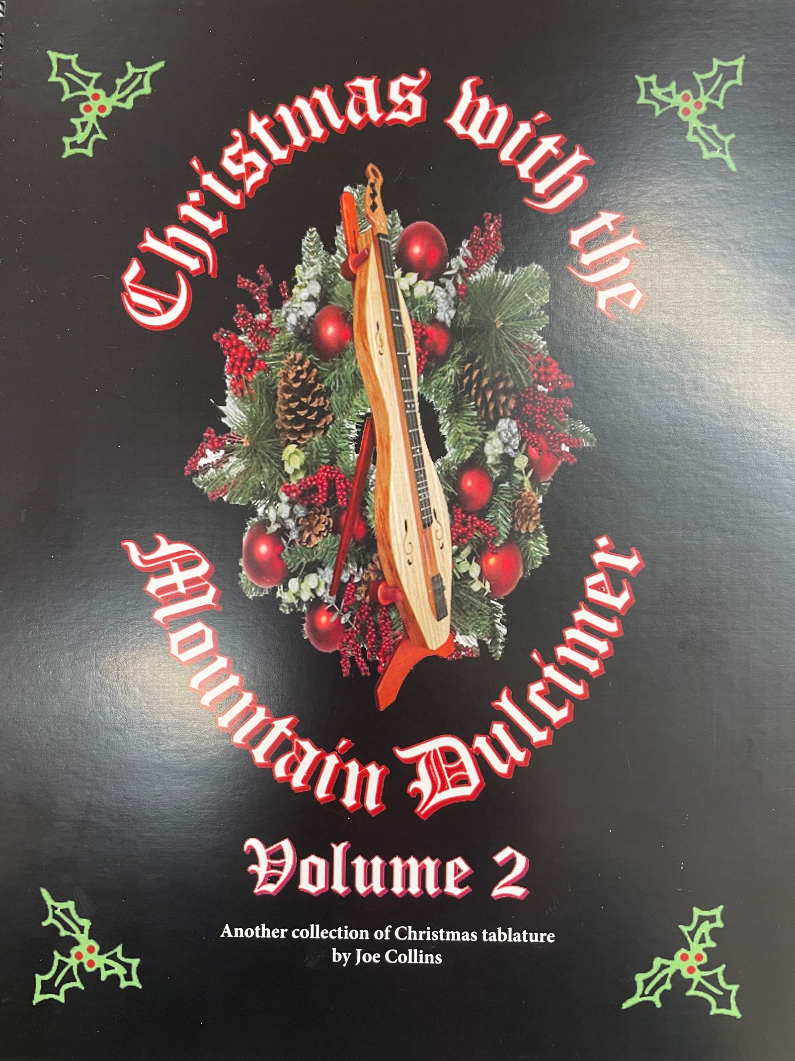 Book cover of "Christmas with the Mountain Dulcimer Vol 2 by Joe Collins" featuring a holiday wreath and dulcimer illustration, with holly decorations wrapping the corners. Includes Christmas favorites.