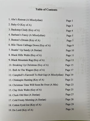 A photo of a DAD Capo 4 by Tom Arnold for an old-time tunes music book, listing song titles and their corresponding page numbers tabbed for dulcimer.