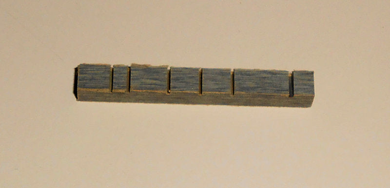 A Micarta Bridge on a white surface.