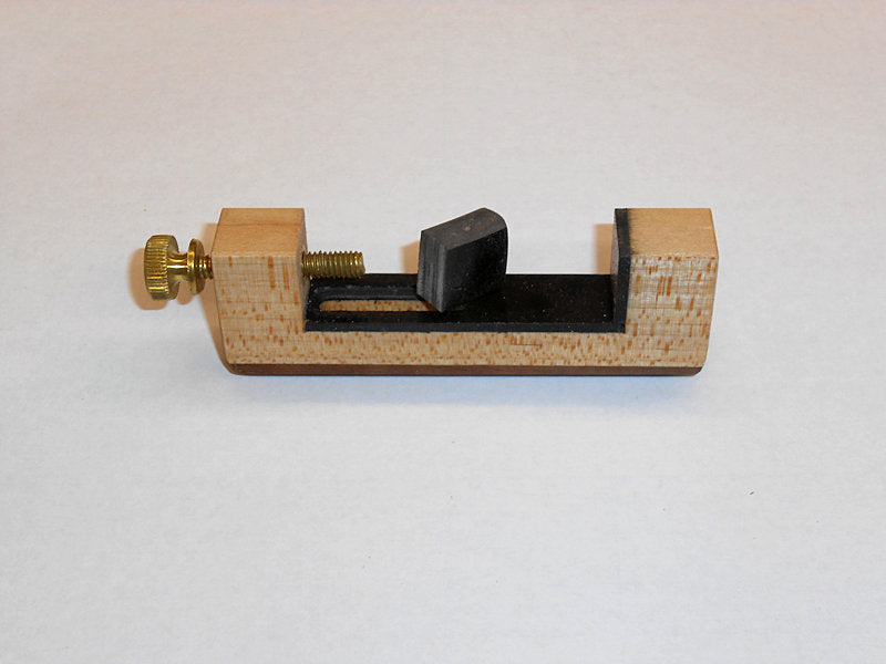 A small wooden box with an Ewing Capo used for dulcimer capoing.