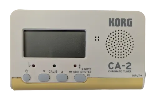 The Korg Tuner - CA2 features a digital display, control buttons, speaker, and input jack—ideal for precise tuning and perfect for brass band musicians.