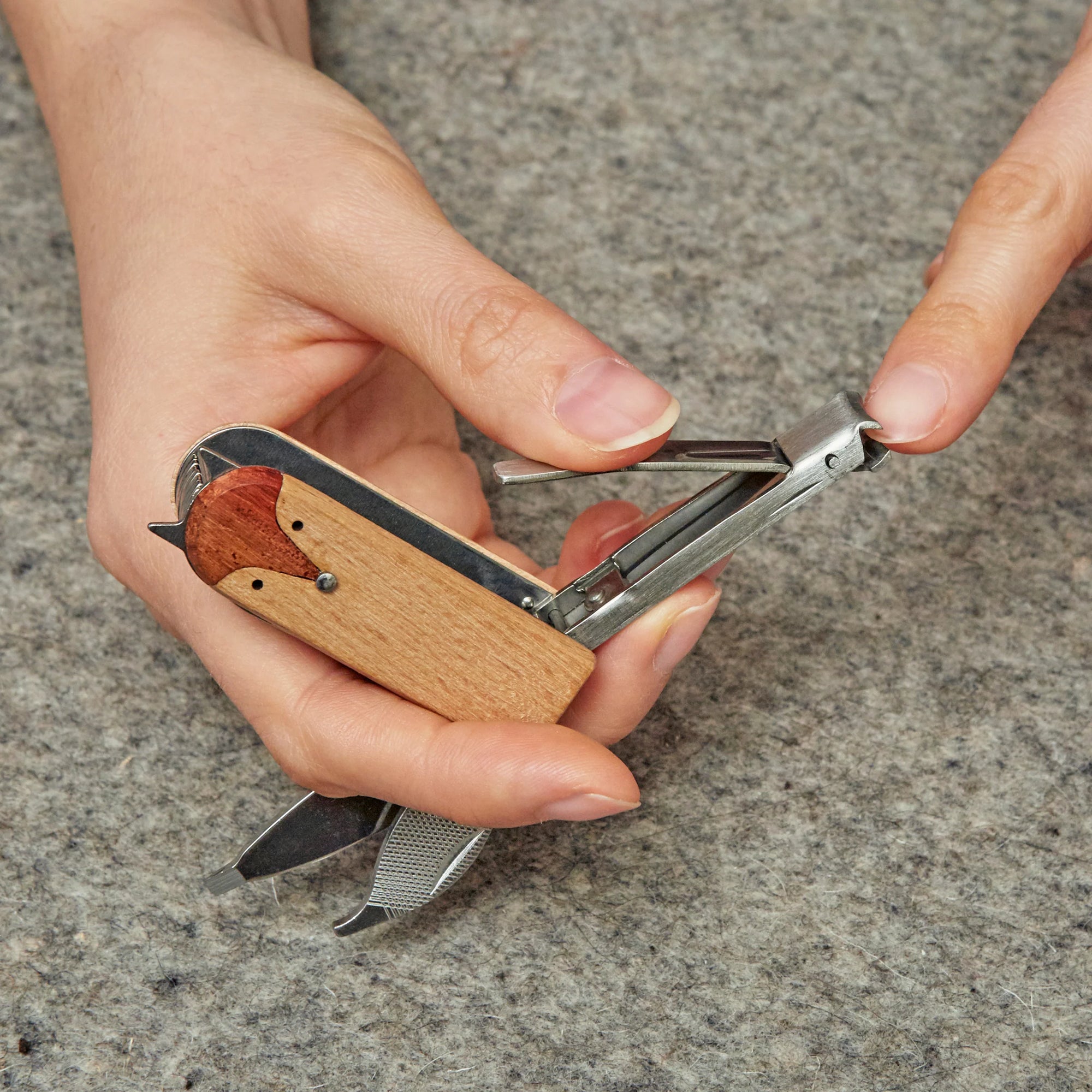 Hands using a Fox Manicure Set with multiple tools including scissors and a nail file.