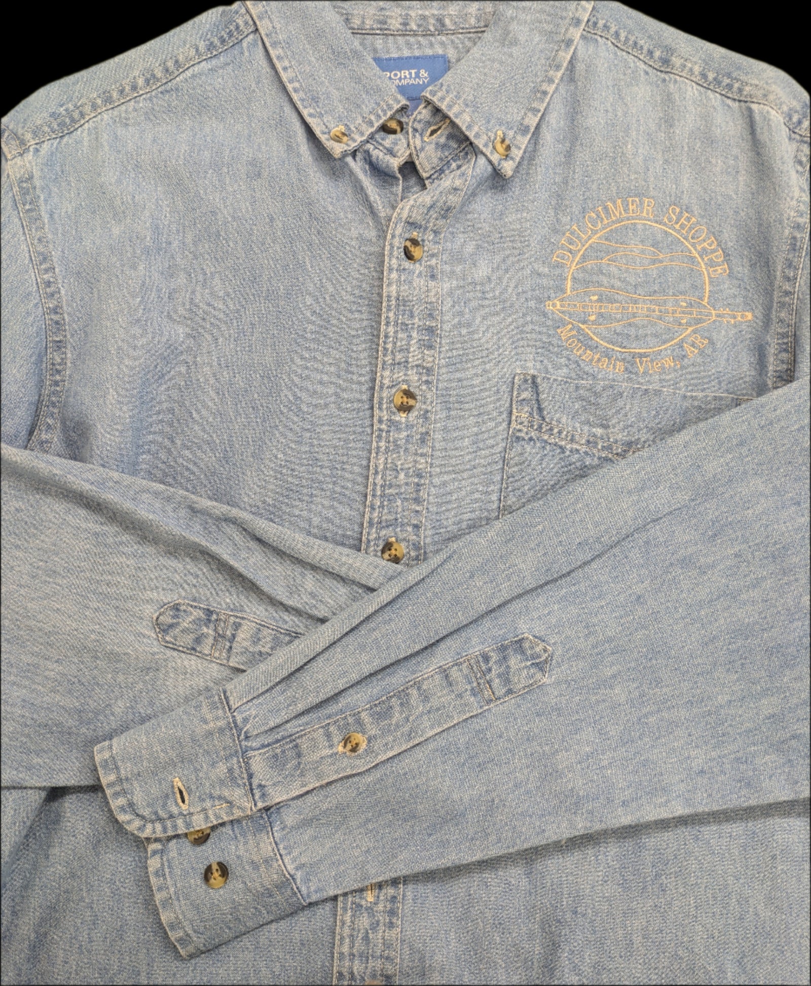 Denim Long Sleeve Shirt in light blue with the Dulcimer Shoppe Logo and "Mountain View, AR" embroidered on the left chest. Sleeves crossed in front add a casual touch.