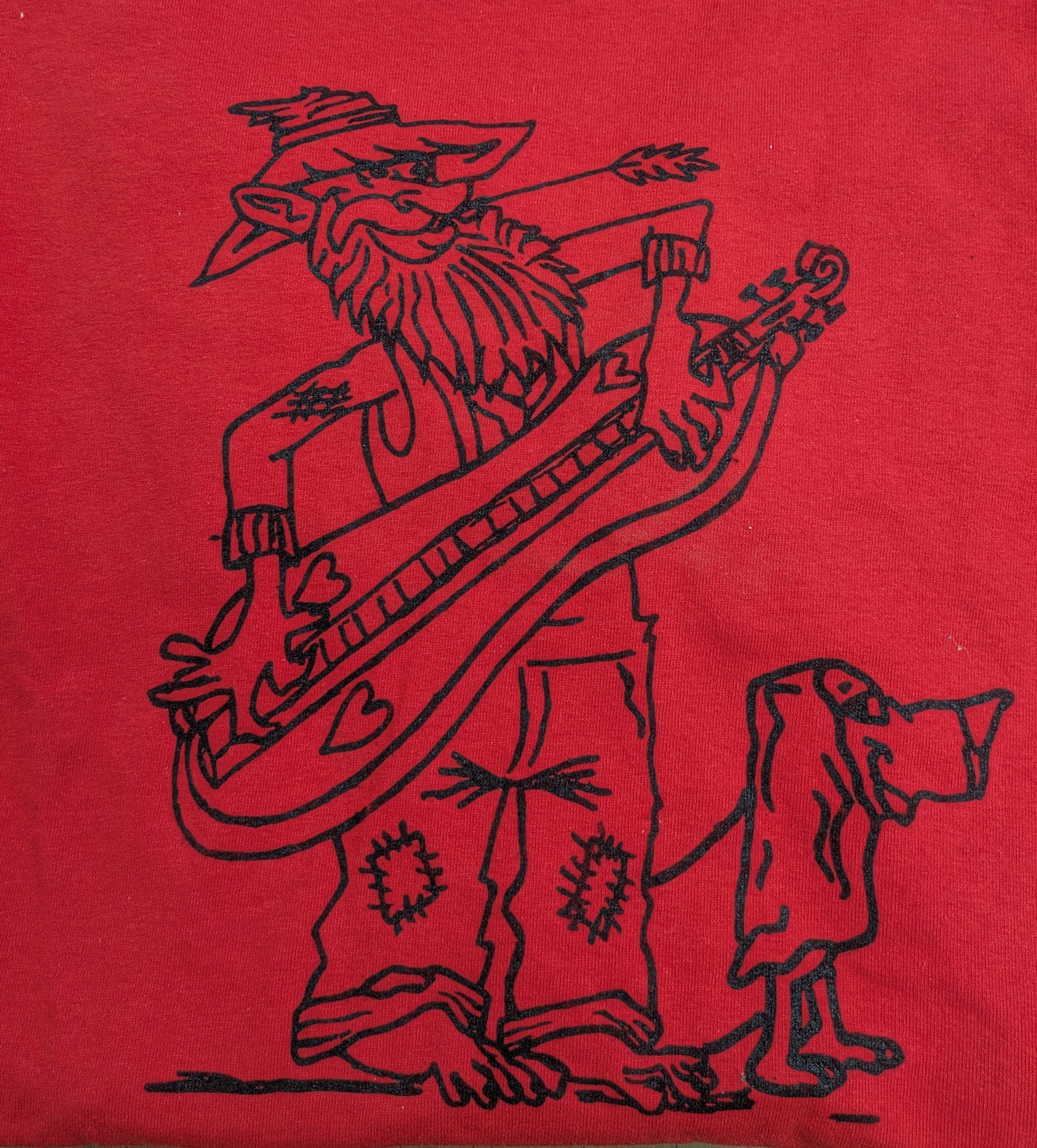 The Long Sleeve T-shirt - Hillbilly Design features a black line drawing on red fabric of a bearded hillbilly with a large guitar and a small dog. Available in sizes Small to 3XL.