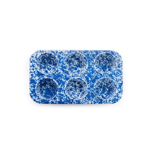 The Splatter Enamelware 6-cup Muffin Tin, shown from above on a white background, features a blue and white speckled design with rounded corners. Its durable construction is finished with smooth porcelain for easy cleaning and lasting quality.