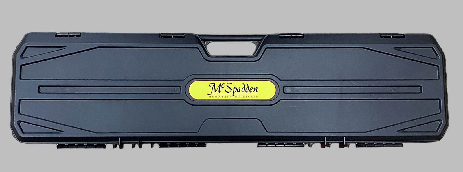 A rectangular black UPGRADE PRICE ONLY - Hard Shell Case with a handle and central yellow "J.M. Spuden Hydrant Solutions" label, custom fit for dulcimer transport, offering secure and stylish protection.