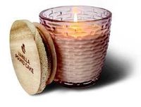 A lit Cathedral Glass Small Vase Swan Creek Candle in a textured pink container sits beside a wooden lid labeled "Vanilla Pound Cake.