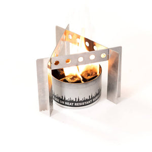 A Portable Camp Stove / Stand Combo with an open flame, containing burning coals, surrounded by a wind guard on a white background, ideal for outdoor cooking.