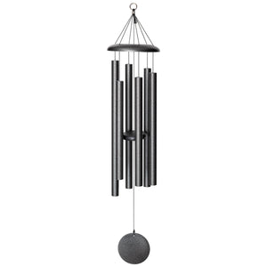 Corinthian Bells® 44-inch Windchime, featuring multiple cylindrical tubes and a circular clapper, hangs elegantly by strings from a small ring. This black wind chime adds depth and flair to any space.