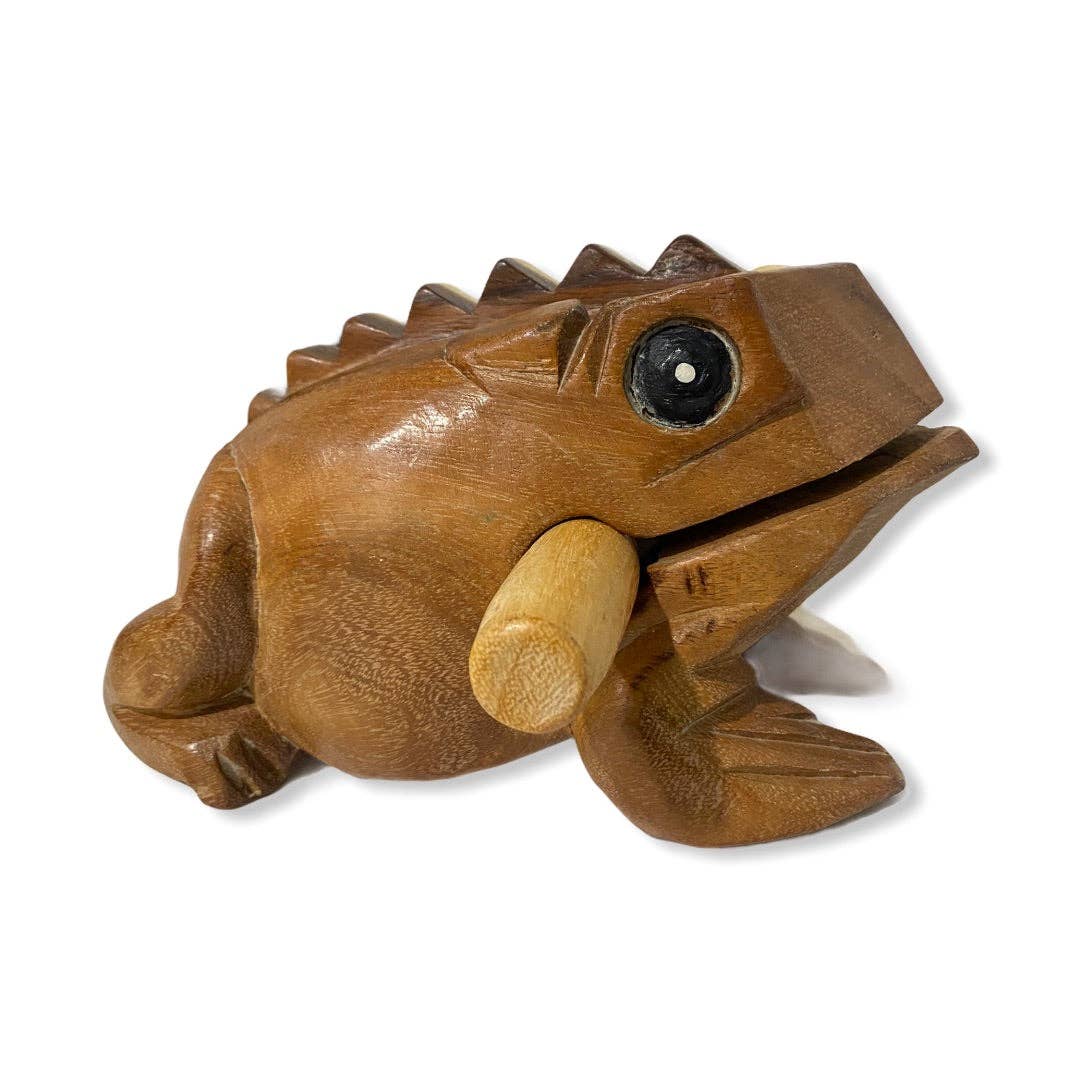 The Natural wooden frog, a handcrafted percussion instrument from Thailand, features a textured surface and includes a stick placed in its mouth, exemplifying quality craftsmanship.