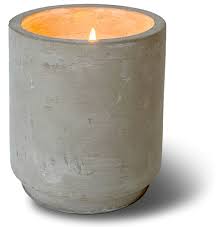 A lit Parisian Courtyard Classic Vase Swan Creek Candle in a cylindrical gray concrete holder on a white background.