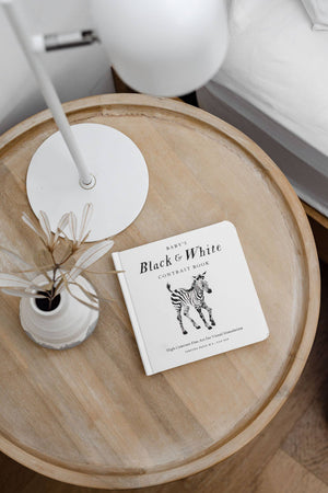 A Baby's Black and White Contrast Book on a bedside table for visual development.