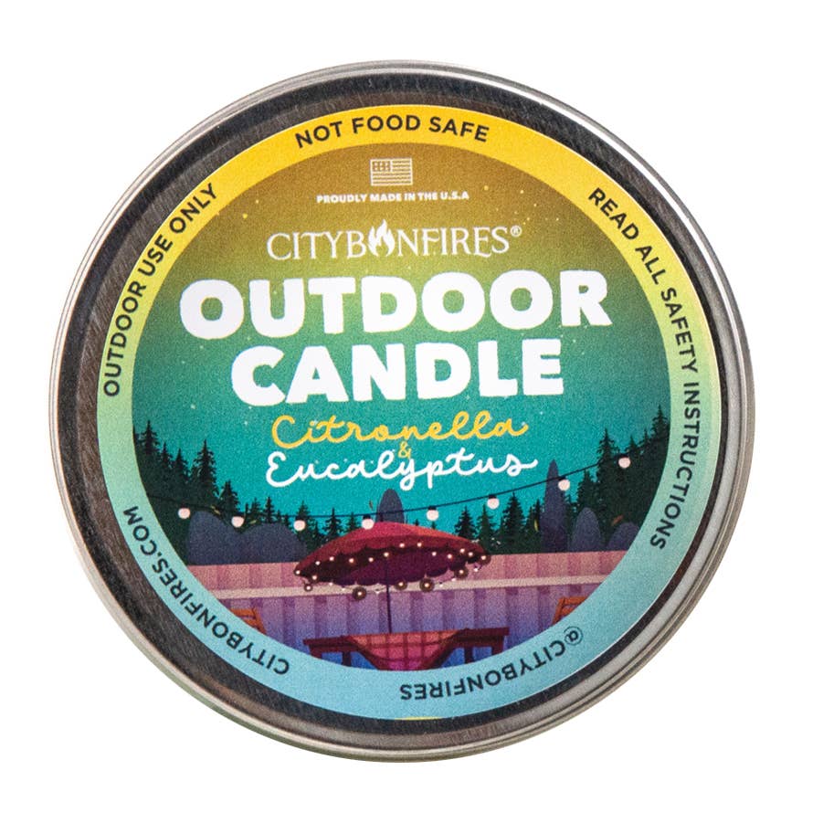 Top view of a circular "The Outdoor Candle - Citronella and Eucalyptus" with citronella and eucalyptus scent, featuring colorful packaging with forest and gazebo graphics.