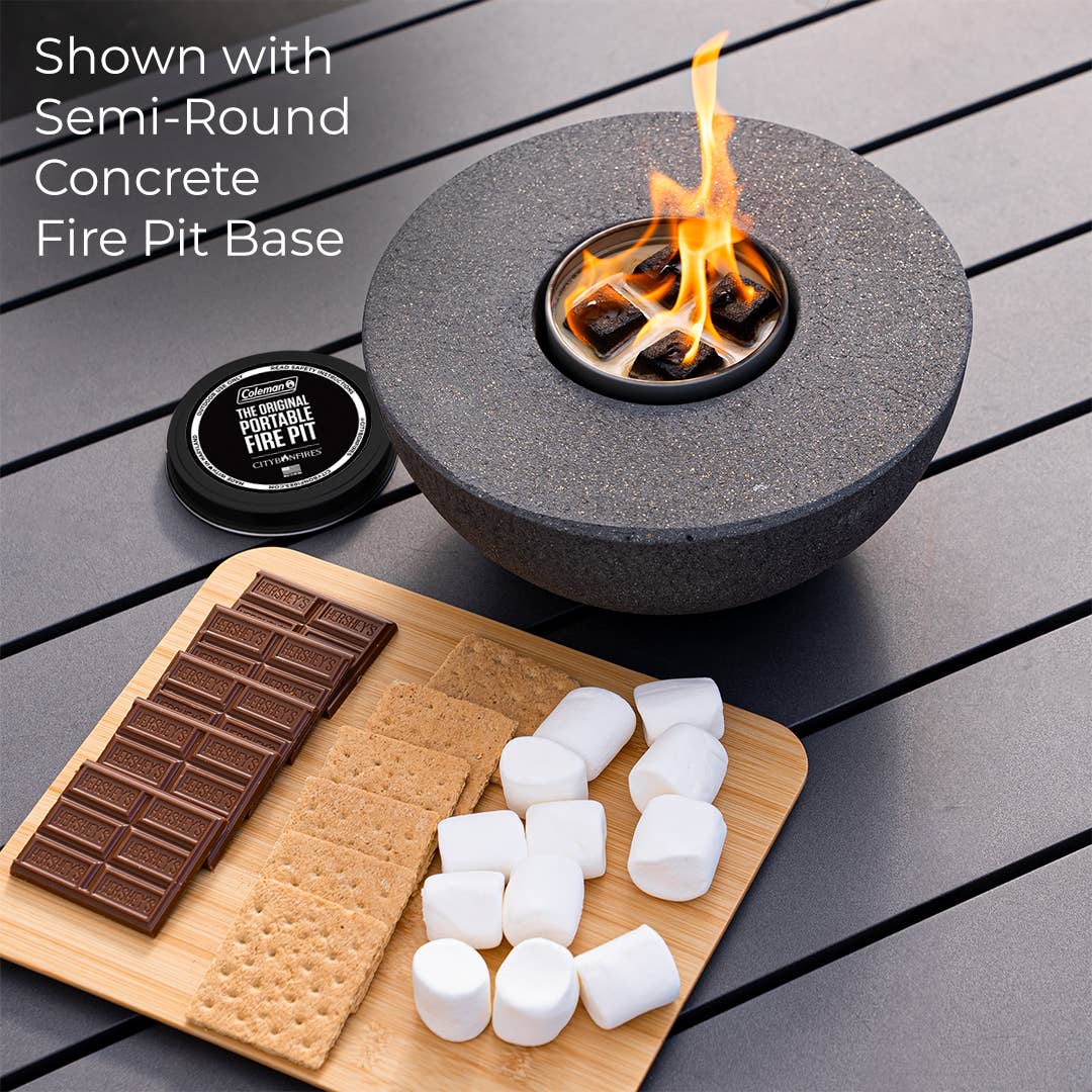 A Mini Portable Fire Pit - City Bonfires® by Coleman® with a flame in the center, next to a wooden board with marshmallows, chocolate, and graham crackers for making s'mores.