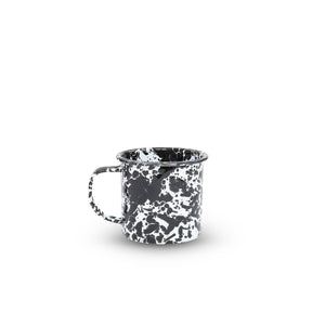 The Splatter Enamelware 16oz Large Mug with a handle features a black and white marbled pattern, perfect for enjoying beverages. This eye-catching enamelware mug is displayed on a plain white background.