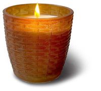 A lit Chestnut Glass Frosted Small Vase Swan Creek Candle in a textured, amber-colored holder casts a shadow to the right.