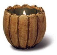 A lit Large Petal Pot Candle in a round, ribbed, brown ceramic holder.