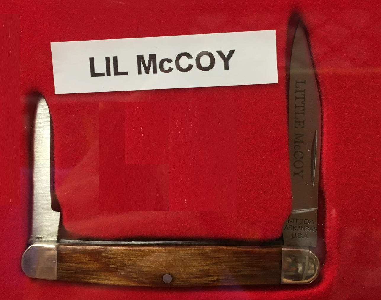 A knife with walnut handle and 2 blades, engraved with the words "Little McCoy".