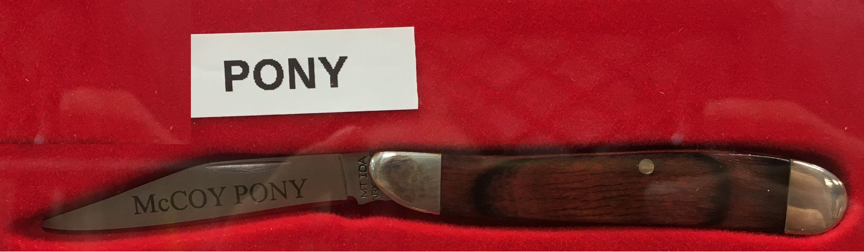 A knife with a McCoy Pony blade and rosewood handle, featuring the word pony.
