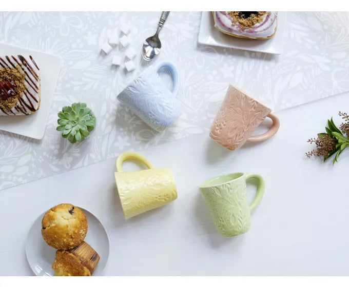 A set of Studio M Coffee Mugs from the Heart Notes collection on a white table.