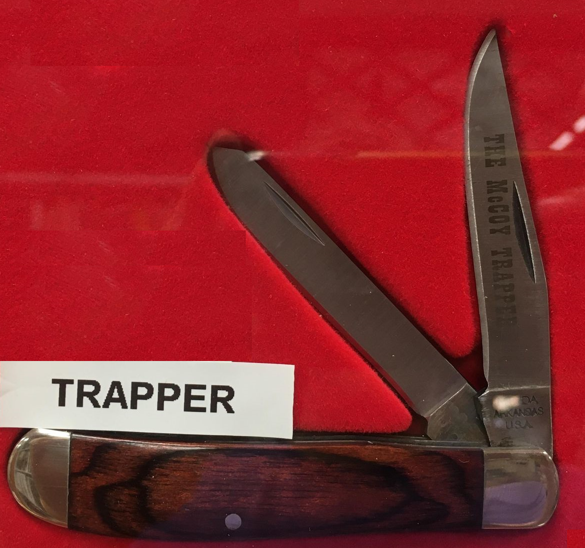 A McCoy Trapper RS with Red Stag bone handle and carbon blades, engraved with the word "trapper".