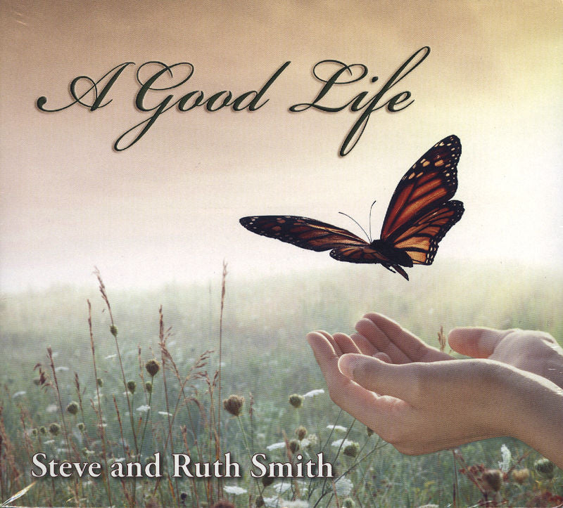 A pair of hands extending towards a butterfly in a field, accompanied by the text "A Good Life" above, and credited with "Steve and Ruth Smith" at the bottom, beautifully encapsulates the spirit of acoustic Americana.