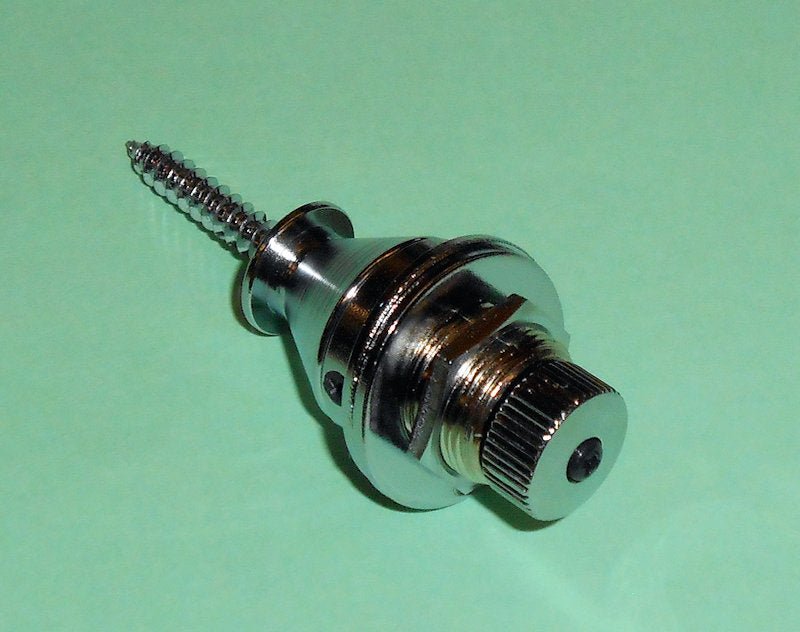 A Gotoh Quick Release Strap Button - Chrome for quick installation on a green surface.