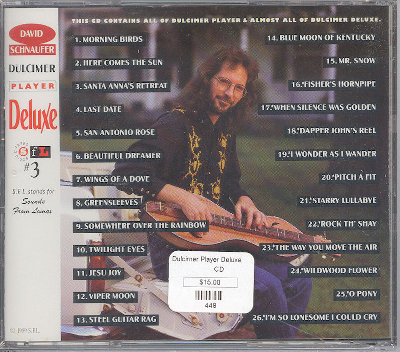 A man seated holding a Dulcimer Player Deluxe on the back cover of a CD titled 'David Schnaufer: Traditional Dulcimer Player Deluxe', featuring the album's tracklist and price.