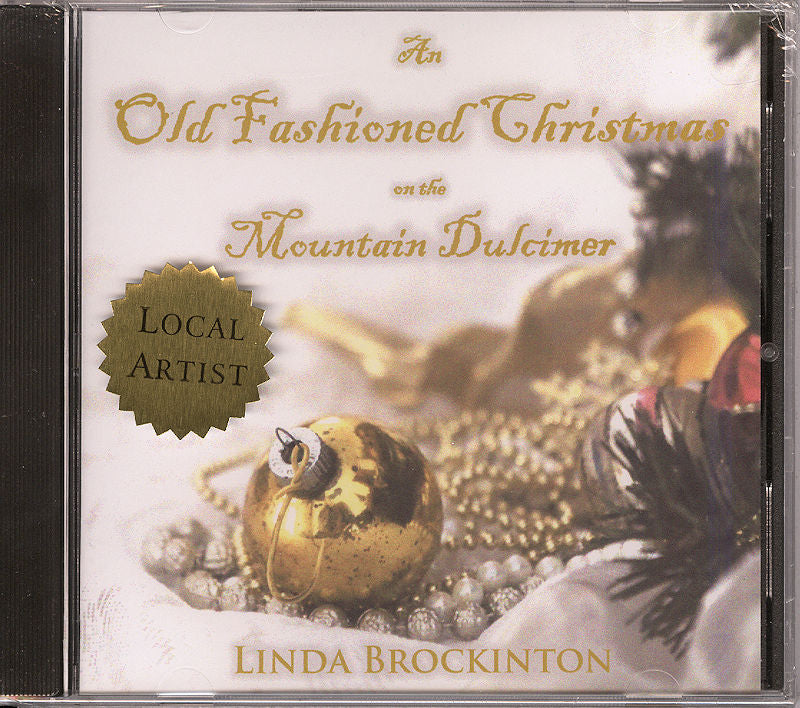 The CD cover for "An Old Fashioned Christmas" by Linda Brockinton, adorned with a gold ornament and pinecones, encapsulates the spirit of classic Christmas melodies.