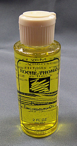 A bottle of Roche-Thomas Fingerboard Oil, serving as a moisturizer, on a blue background.