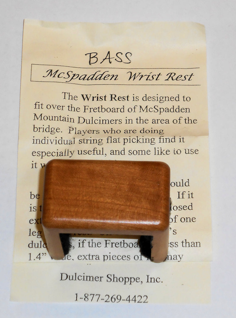 A Cherry Wood Wrist Rest for Bass Dulcimer with a word "bass" carved on it.