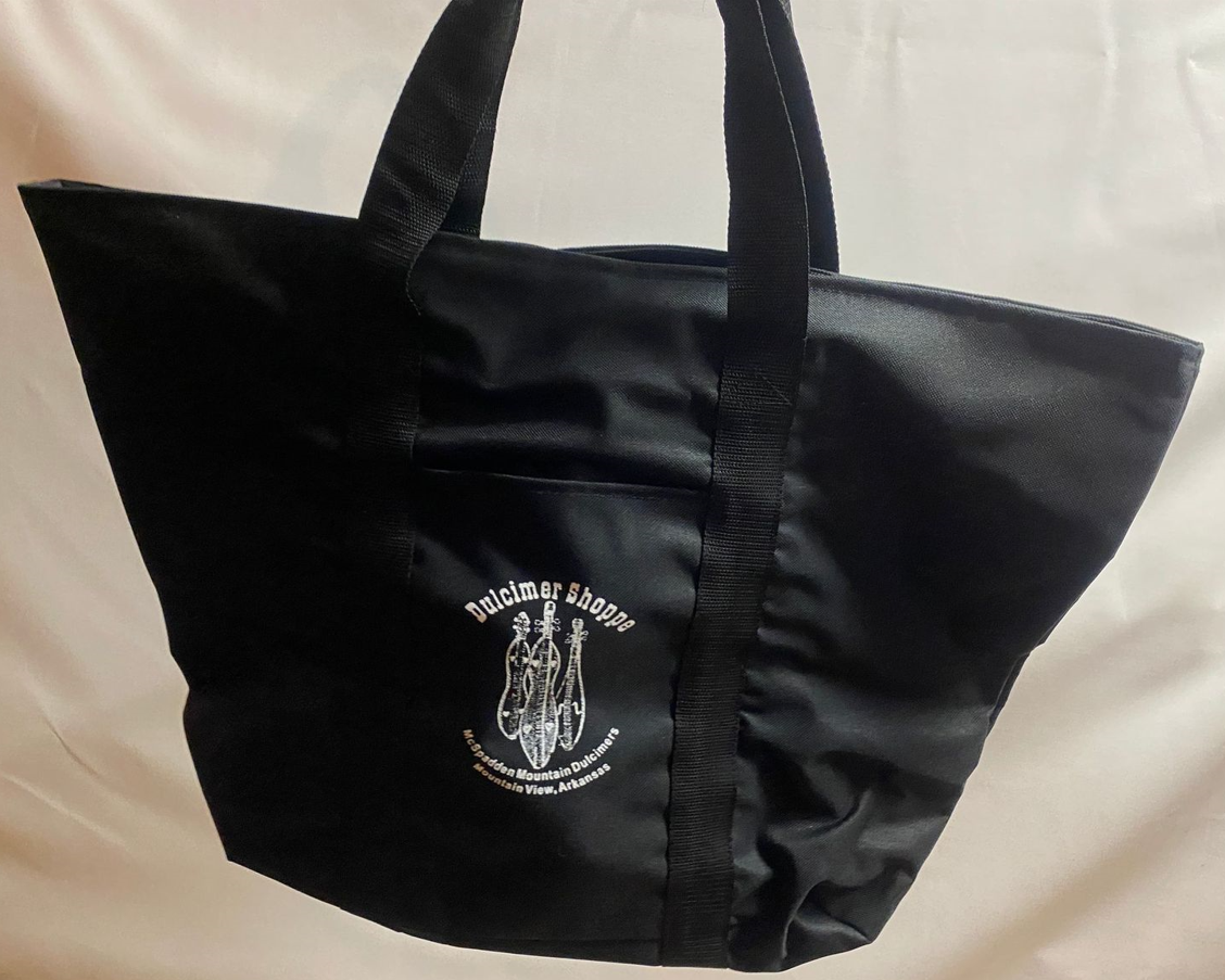 A Dulcimer Shoppe Tote Bag with handles and a white logo on it.